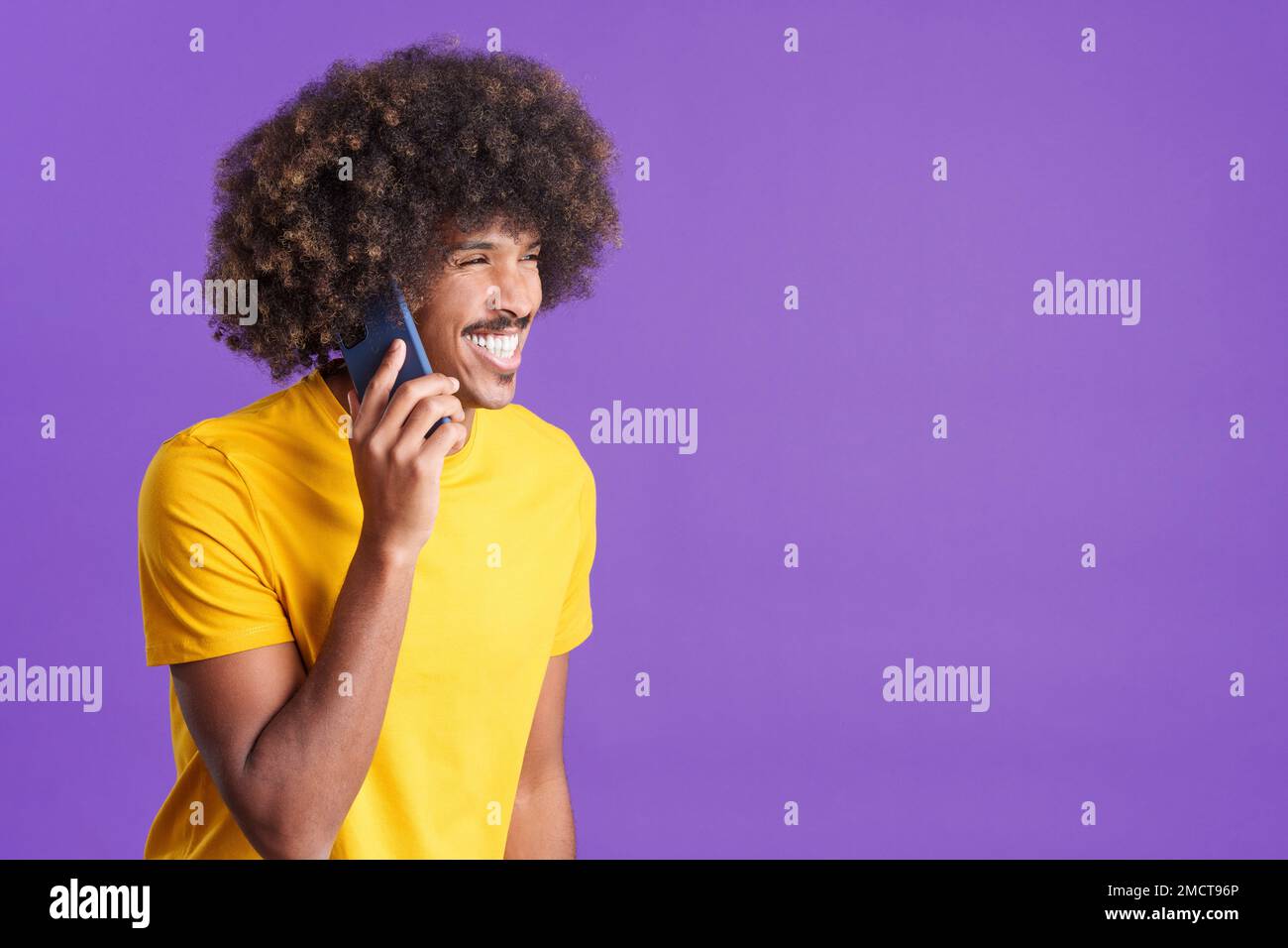 Un uomo africano sorridente che parla con il cellulare Foto Stock