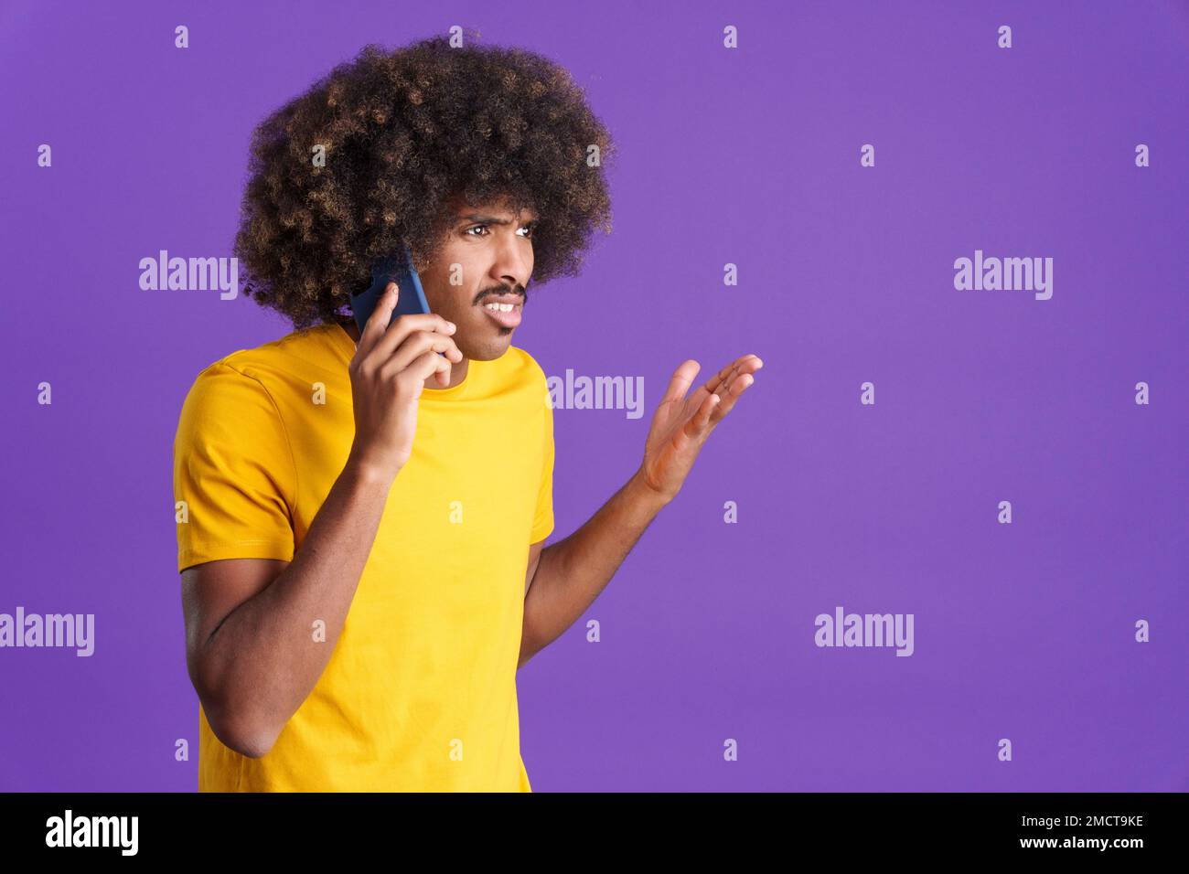 Un africano arrabbiato che parla con il cellulare Foto Stock