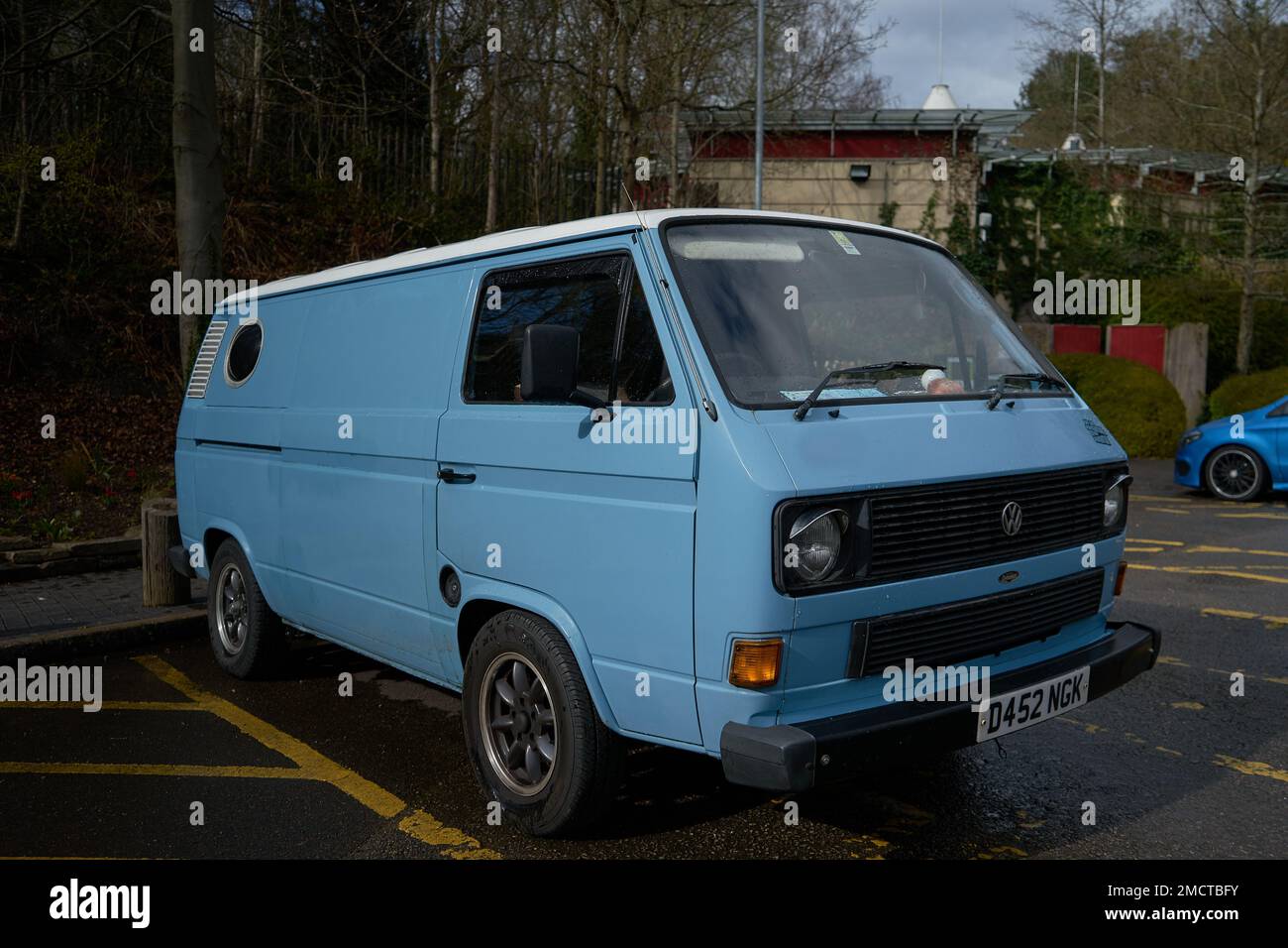 Un furgone VW vintage raffreddato ad aria con ruote post-vendita si trova in un parcheggio auto. Questi iconici Volkswagens sono un veicolo molto ricercato. Foto Stock
