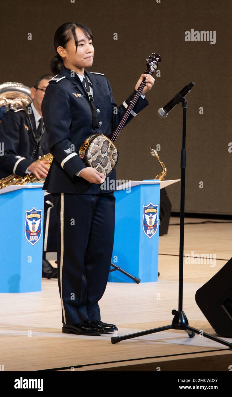 Japan Air Self-Defense Force Airman 1st Class Mayuko Mizuno, Un membro della Southwestern Air Defense Force Band esegue una canzone tradizionale di Okinawan “Asadoya Yunta” su uno strumento noto come sanshin durante un concerto di jazz congiunto con la III Marine Expeditionary Force Band al Naha Cultural Arts Theater, Naha, Okinawa, Giappone, il 10 luglio. 2022. Lo scopo del concerto era quello di mostrare Tomo Ni, una frase giapponese per la convivenza, che descriveva il rapporto con gli alleati, che si trovava insieme in difesa dei valori condivisi, della pace e di un indo-Pacifico libero e aperto. Foto Stock