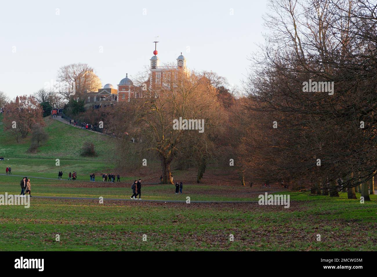 Persone che camminano nel Greenwich Park in una giornata d'inverno con il Royal Observatory sulla collina sopra. Londra Inghilterra. Foto Stock