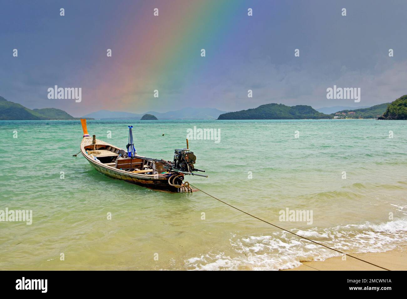 Barca su una spiaggia solitaria a Phuket, Rainbow, Thailandia Foto Stock