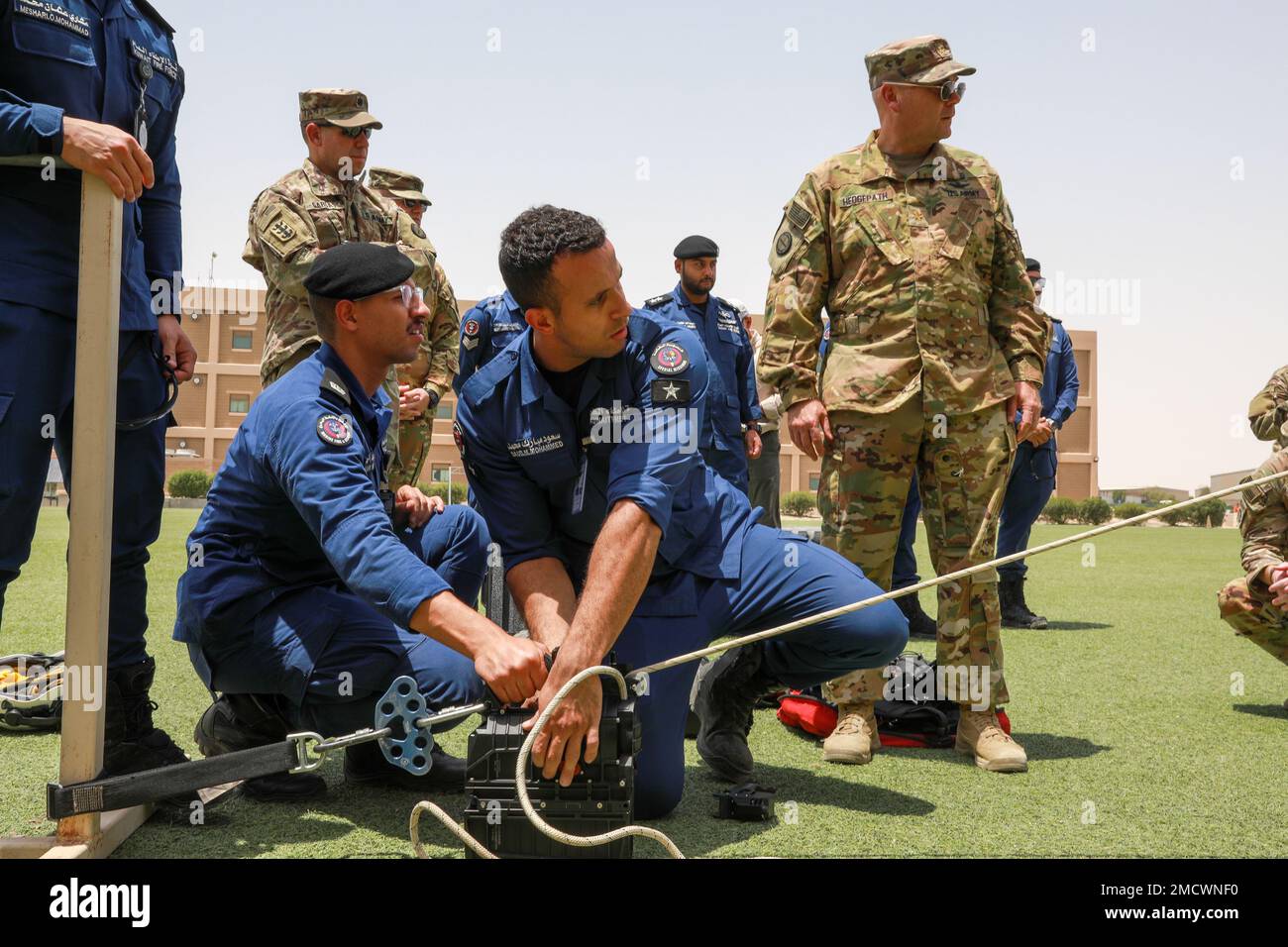 I soldati della 35th° Divisione di Fanteria e i membri della forza antincendio del Kuwait conducono uno scambio di esperti in materia (SMEE) sul campo di Arifjan, in Kuwait. La formazione si è focalizzata sulle operazioni di recupero del personale e sulle capacità di lotta contro il salvavita, seguita da un'evacuazione medica simulata con supporto per il sollevamento aereo dal 7-158th Aviation Regiment - GSAB. Foto Stock