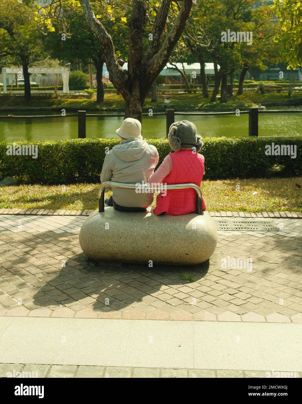 Una vecchia coppia seduta al banco del parco Foto Stock