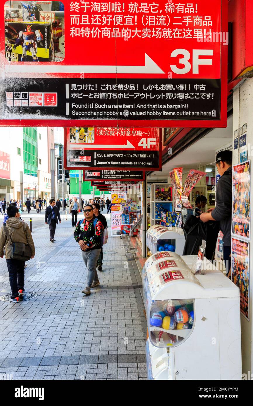 Tokyo, Akihabara. Street view lungo l'ingresso al paradiso Hobby store con righe di cartelli appesi elencando ciascun piano il contenuto. La gente a piedi. Foto Stock
