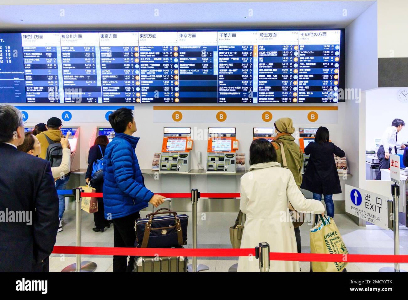 Tokyo Haneda international airport. Un terminale interno. Le persone che usano una fila di bus ticket macchine contrassegnate A e B, con calendario illuminata sopra. Foto Stock