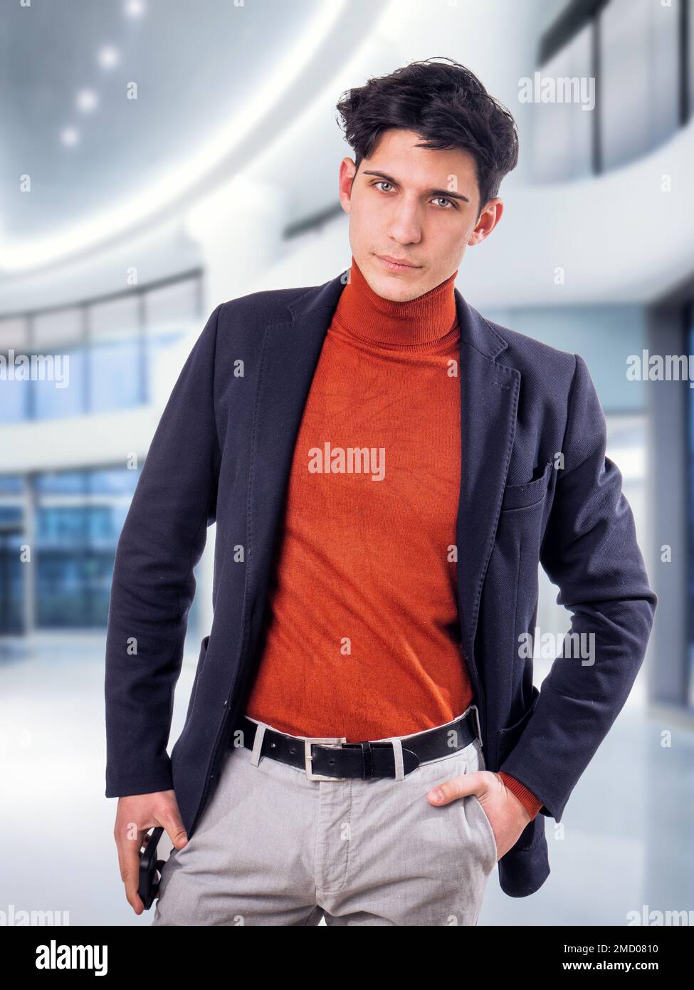 Bel giovane lavoratore maschile in ufficio, in piedi Foto Stock