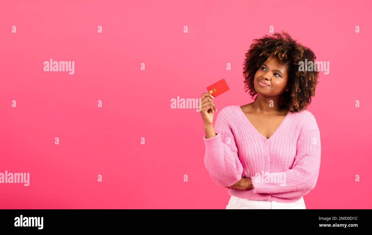 Premuroso allegro millenario afroamericano curly signora shopaholic con carta di credito guardare lo spazio libero Foto Stock