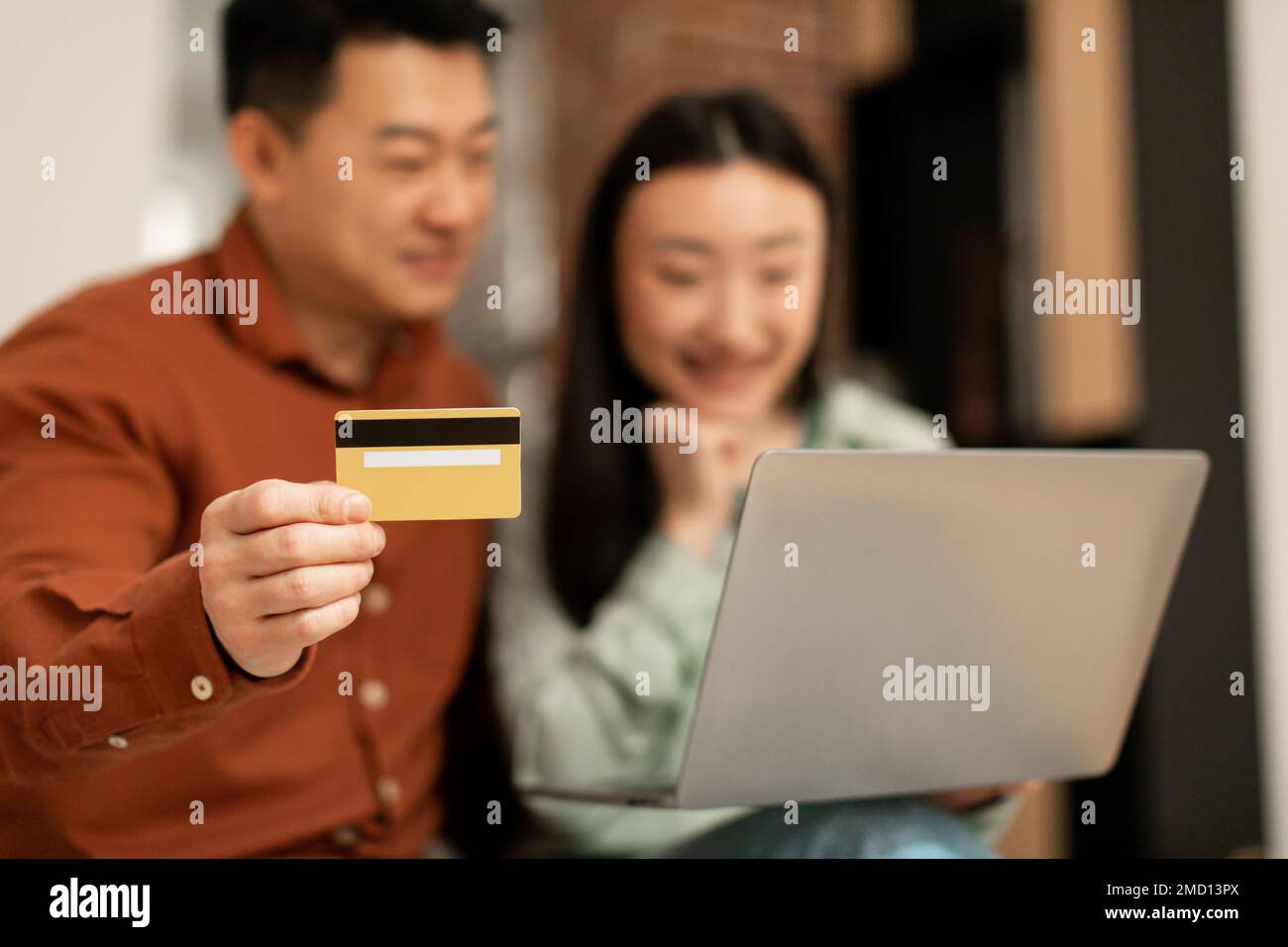 Shopping online. Coppia asiatica che effettua acquisti su laptop, uomo con carta di credito, utilizzando il servizio bancario sul web Foto Stock
