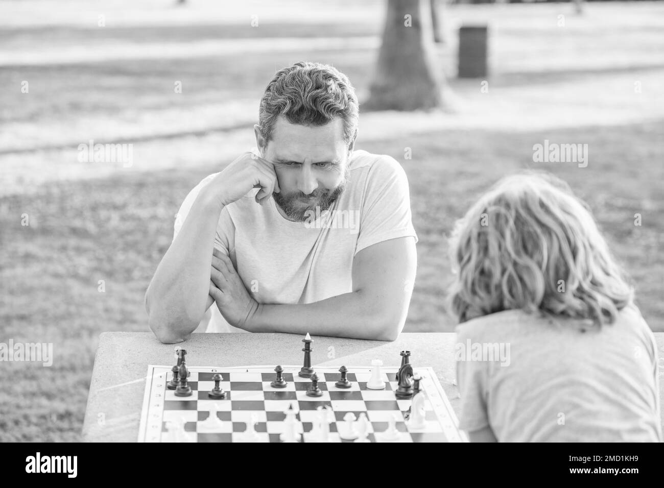 tutorship. papà e capretto giocare gioco logico. padre e figlio giocare a scacchi al tavolo Foto Stock
