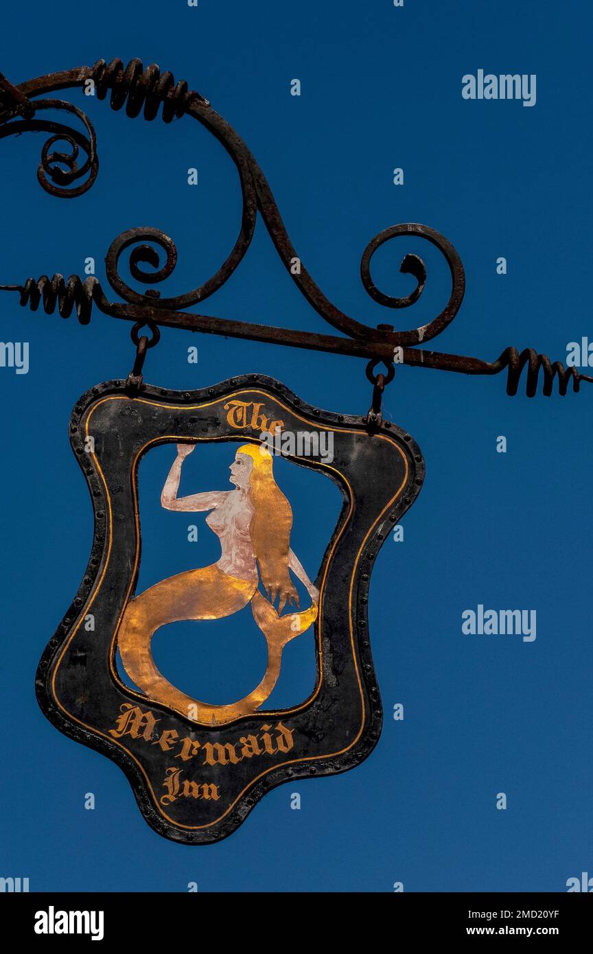 Oscillazione libera… Segno nero e oro in ferro battuto locanda, centrata su una sirena con lunghi capelli dorati e una coda dorata, promuovendo l'antica Mermaid Inn in Mermaid Street, Rye, East Sussex, Inghilterra, UK. La struttura in legno, ricostruita nel 1420, ha cantine a volta in pietra risalente al 1156 e un passaggio segreto che conduce all'Olde Bell Inn nelle vicinanze. Foto Stock