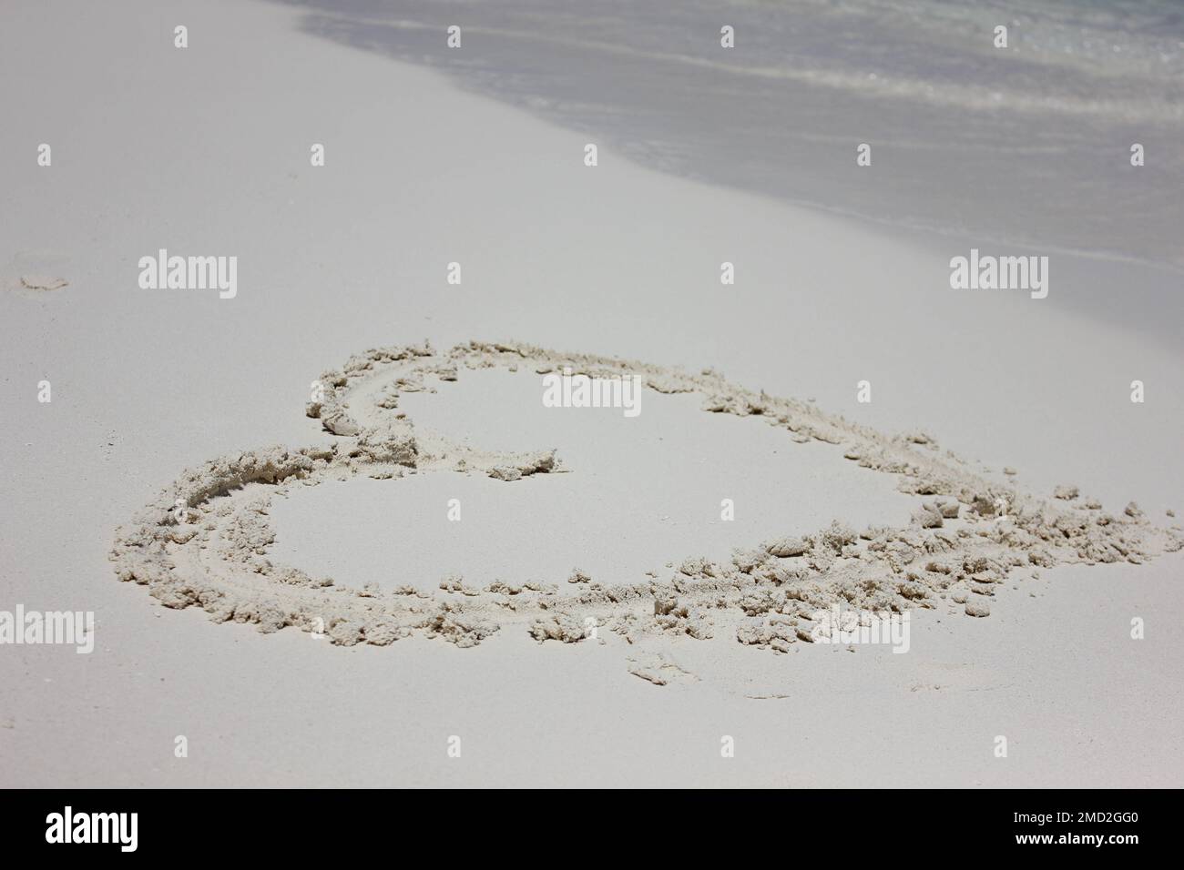 Cuore disegnato nella sabbia. Sfondo spiaggia. Segno di amore che scrive sulla sabbia. Il concetto di turismo di San Valentino o sfondo Foto Stock