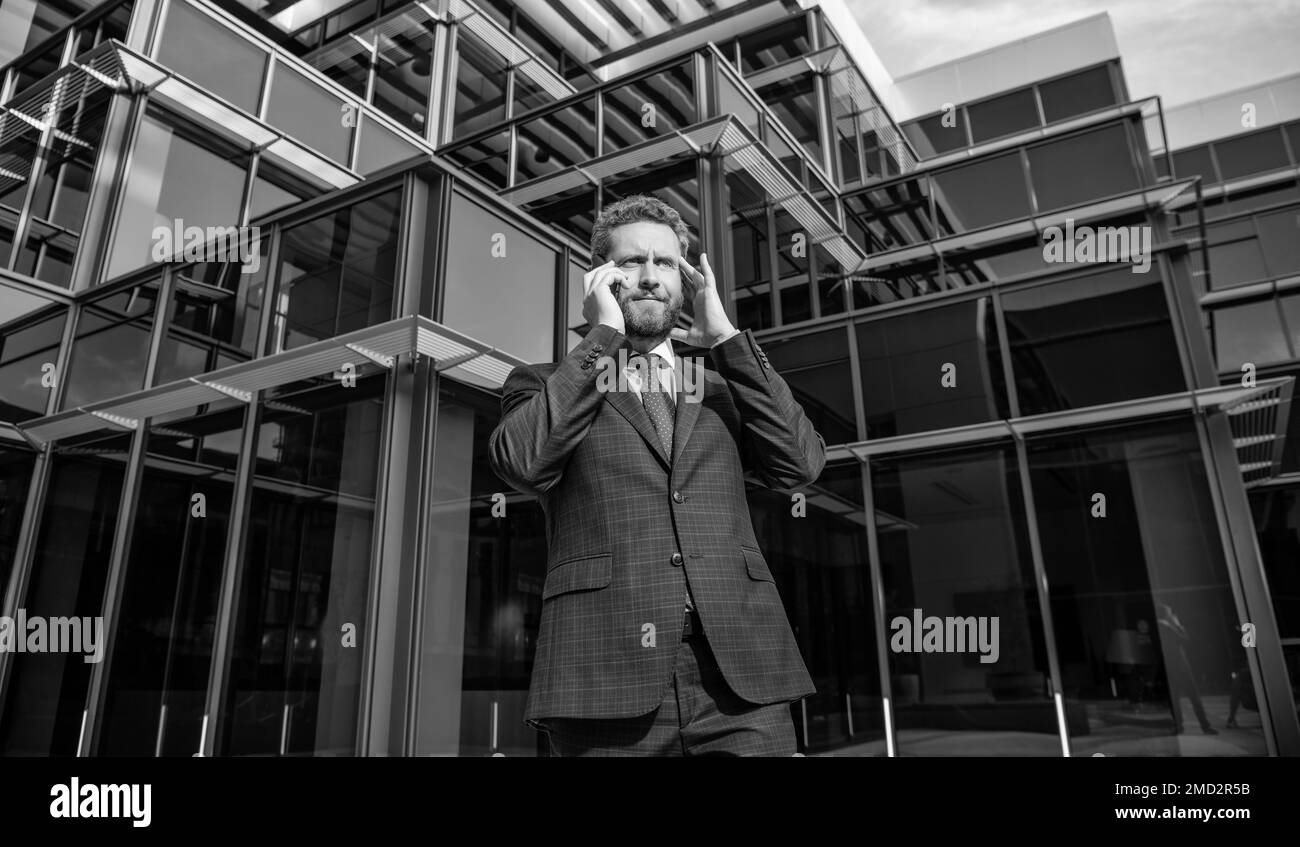 preoccupato e stressato uomo d'affari maturo in formalwear parlare al telefono all'aperto, fallimento Foto Stock