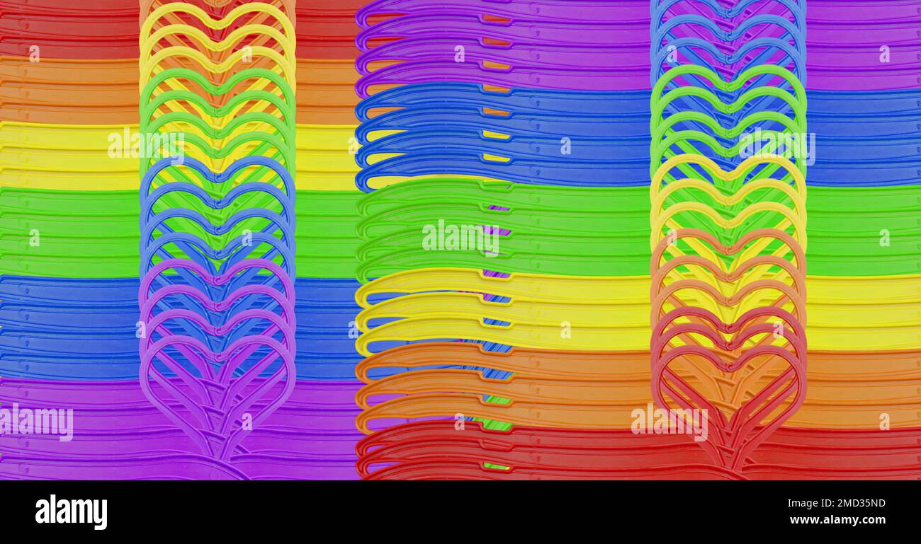 Grucce in plastica color arcobaleno allineate e riunite per formare una forma a cuore. Foto Stock