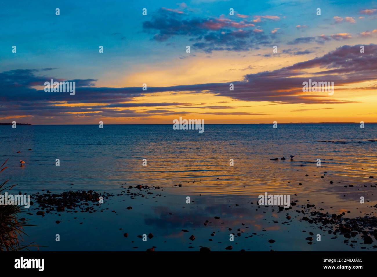 Bellissimo tramonto negli ultimi momenti dell'ora d'oro, riflettendo sulle acque di Lough Neagh, Irlanda del Nord Foto Stock