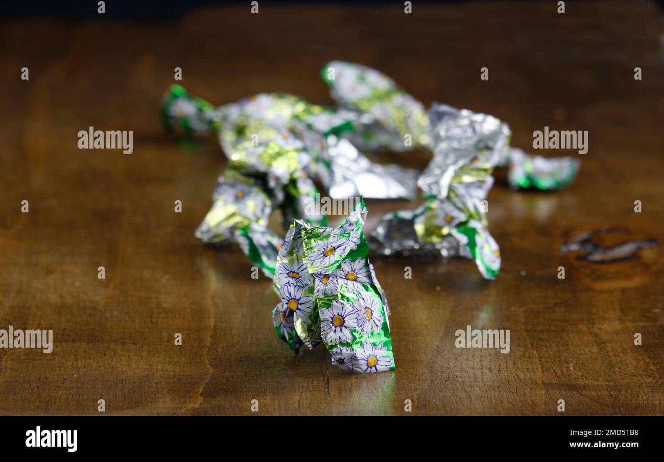 Fogli di caramella su tavola di legno. I dolci sono malsani Foto Stock