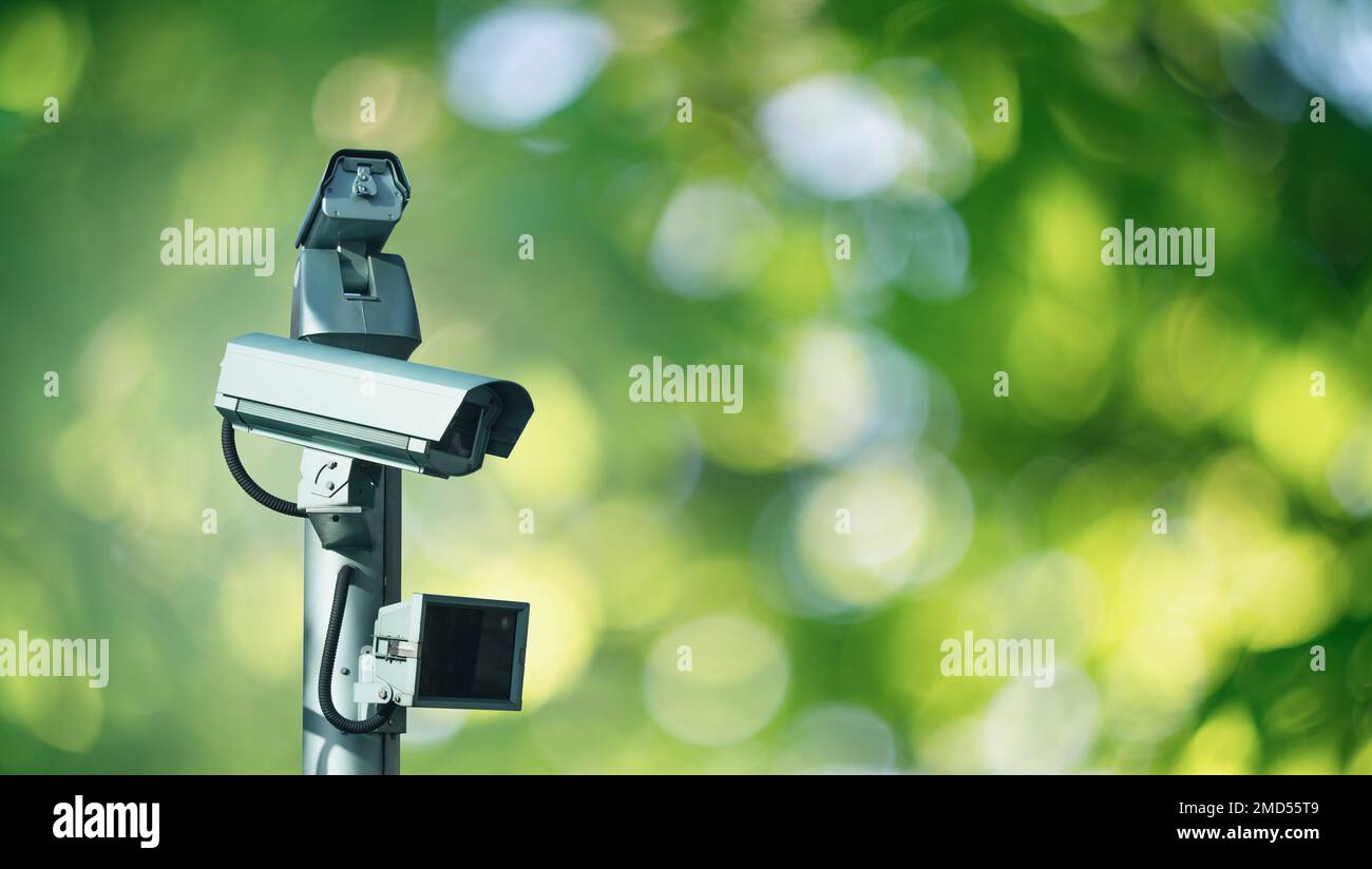 Telecamera di sorveglianza con sensore di movimento su sfondo verde. Sicurezza perimetrale Foto Stock