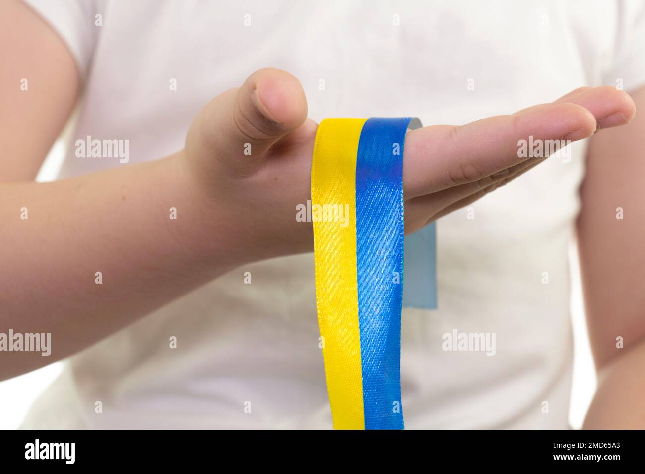Una ragazza in una T-shirt bianca tiene in mano un nastro giallo-blu (primo piano). Bandiera dello Stato dell'Ucraina. Simbolo nazionale dell'Ucraina. Patriot Foto Stock