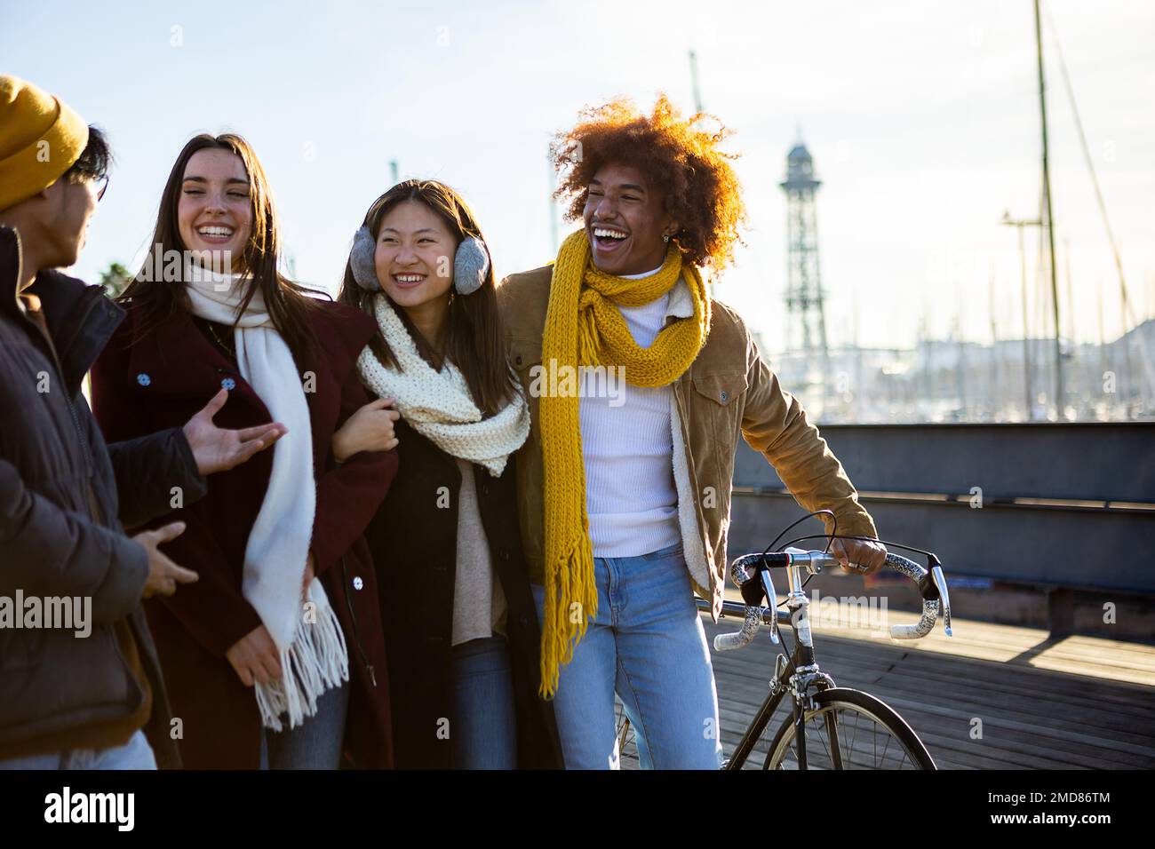 Gruppo di amici felici multietnici che camminano per strada e parlano insieme. Foto Stock