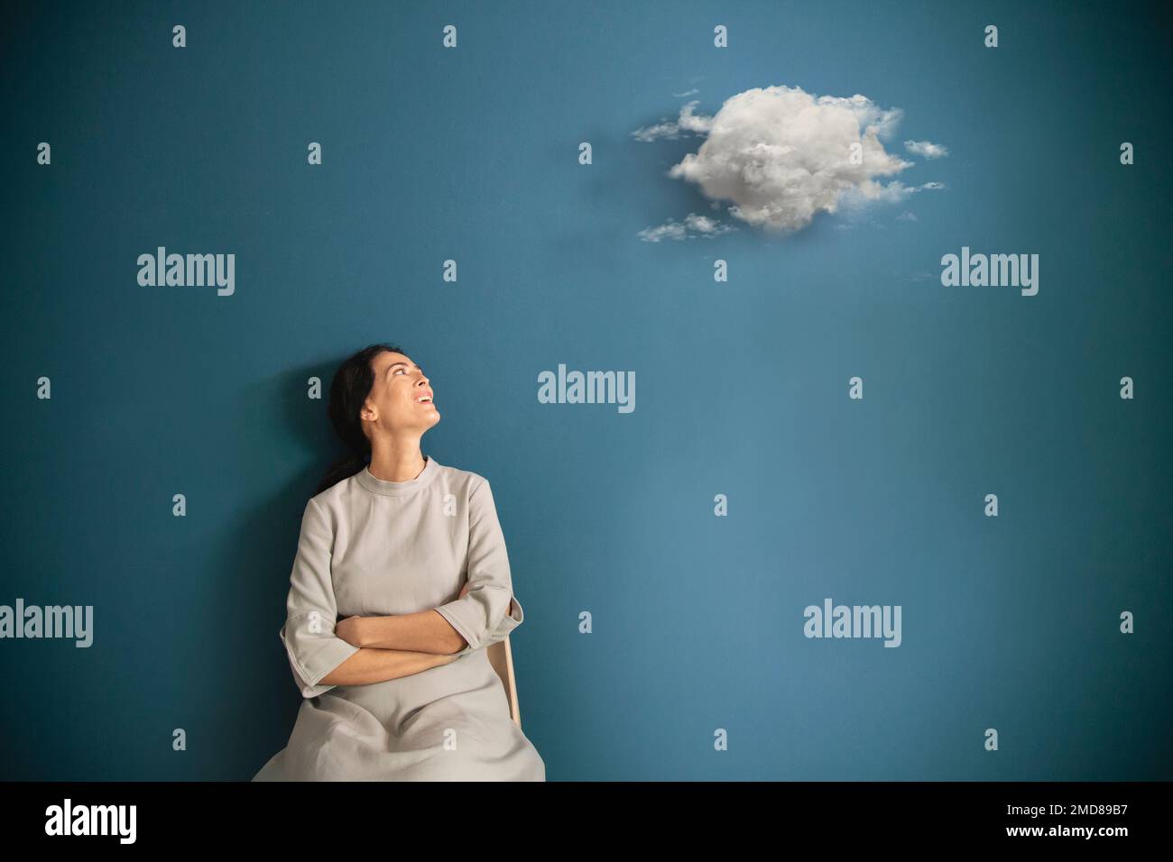 donna osserva stupefatto surreale nuvola nella sua stanza, concetto astratto Foto Stock