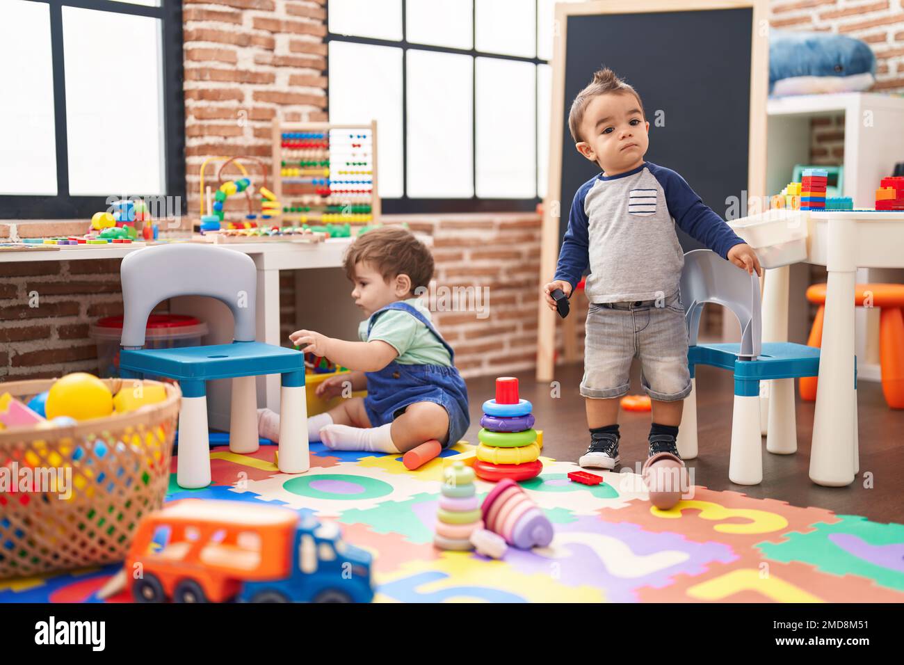 Due bambini giocano con i giocattoli all'asilo Foto stock - Alamy
