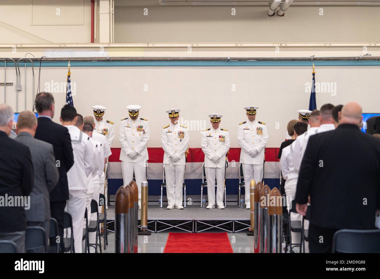 Leadership e ospiti inchinano la testa in preghiera durante una cerimonia tenuta per elevare Unmanned Undersea Vehicle Squadron (UVRON) 1 ad un comando maggiore della forza sottomarina e stabilire Unmanned Undersea Flotilla (UUV Flotilla) 1 come comando subordinato alla base navale Kitsap-Keyport, Washington 14 luglio 2022. La cerimonia è stata anche un cambio di comando per UUVRON-1, con il capitano Jason Weed che allevia il CMdR. Robert Patchin. Foto Stock