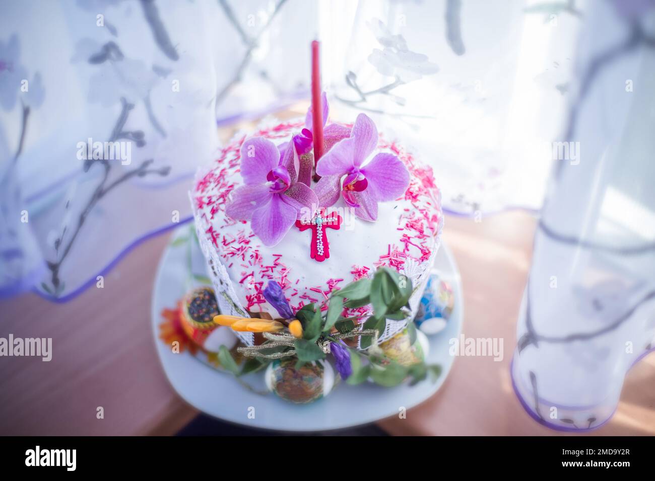 Bella torta di Pasqua decorate con freschi fiori di magnolia e candela sulla finestra. consacrazione di torta di Pasqua. In casa pasca con germoglio di primavera Foto Stock