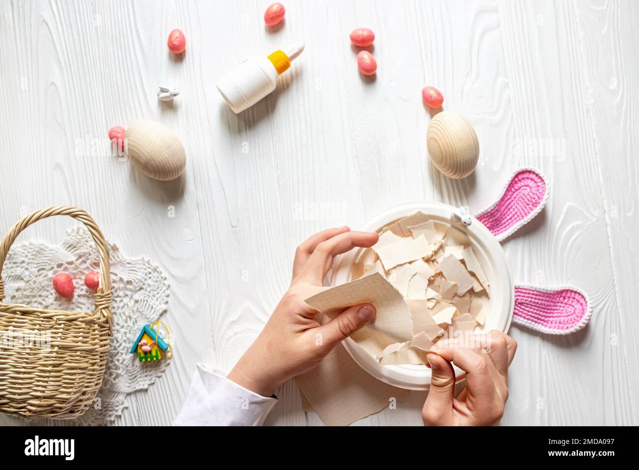 Idee fai da te per creare un arredamento di Pasqua. Istruzioni passo per passo per preparare le uova da papier mache. Passo 2 mani strappare la carta per fare le uova di Pasqua Foto Stock