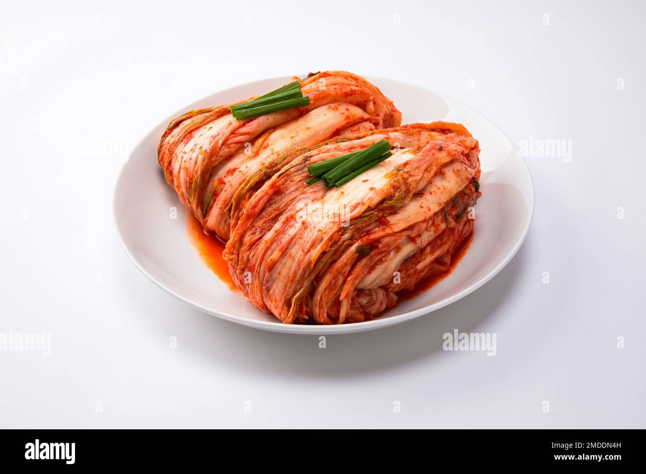 Kimchi coreano. Tradizionale kimchi di cavolo coreano su un piatto bianco. Sfondo bianco, primo piano. Foto Stock
