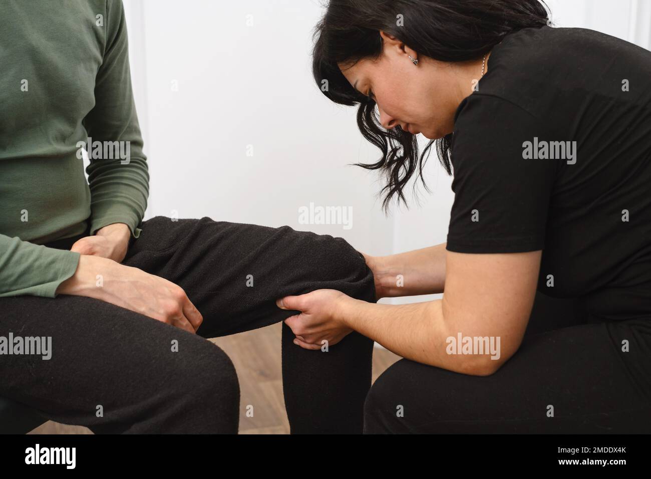 Terapia del ginocchio. Paziente alla fisioterapia che fa gli esercizi fisici con il suo terapista. centro di riabilitazione. Trattamento alternativo osteopata Foto Stock
