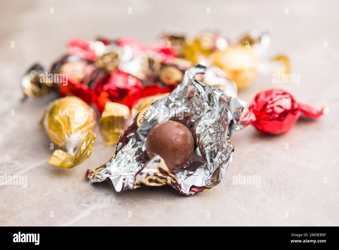 Caramella al cioccolato dolce avvolta in foglio sul tavolo da cucina. Foto Stock