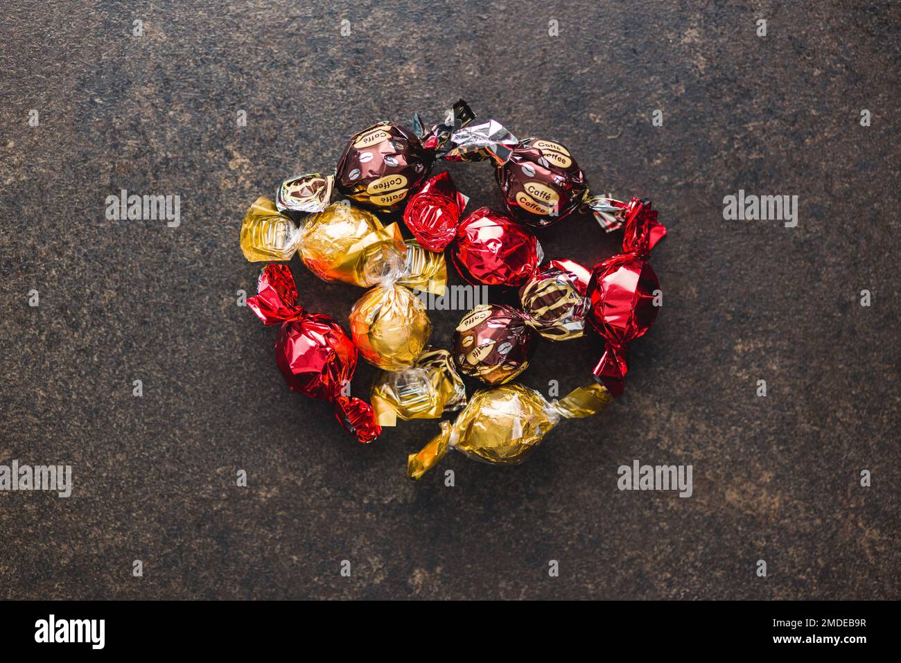 Caramelle dolci avvolte in foglio sul tavolo da cucina. Vista dall'alto. Foto Stock