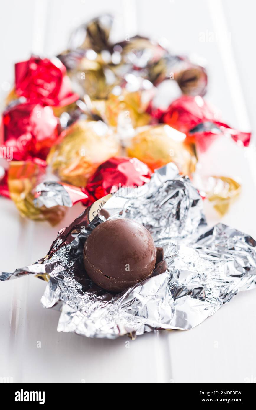 Caramella al cioccolato dolce avvolta in foglio sul tavolo da cucina. Foto Stock