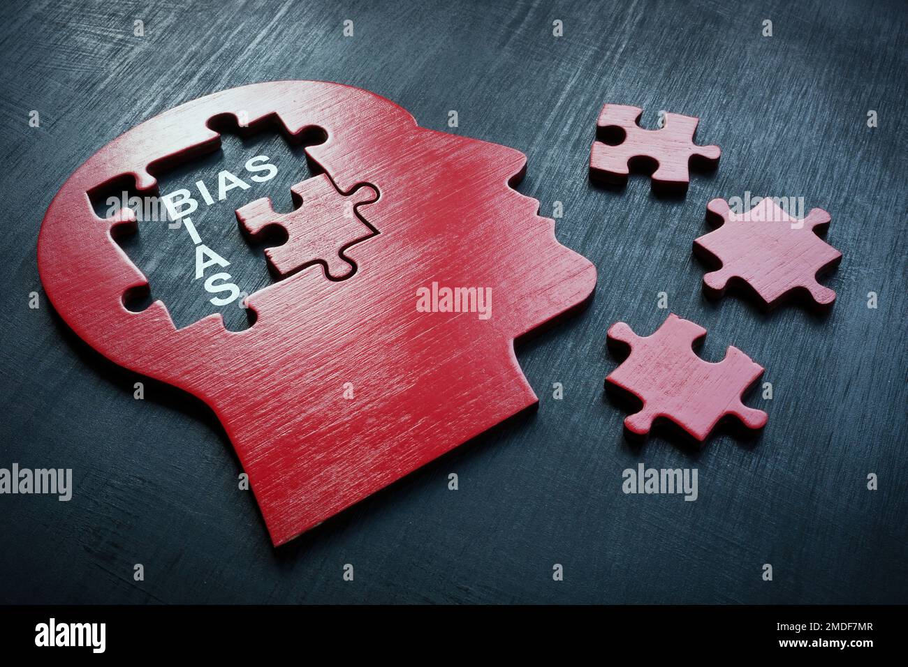Una testa con pezzi di puzzle e bias parola. Foto Stock