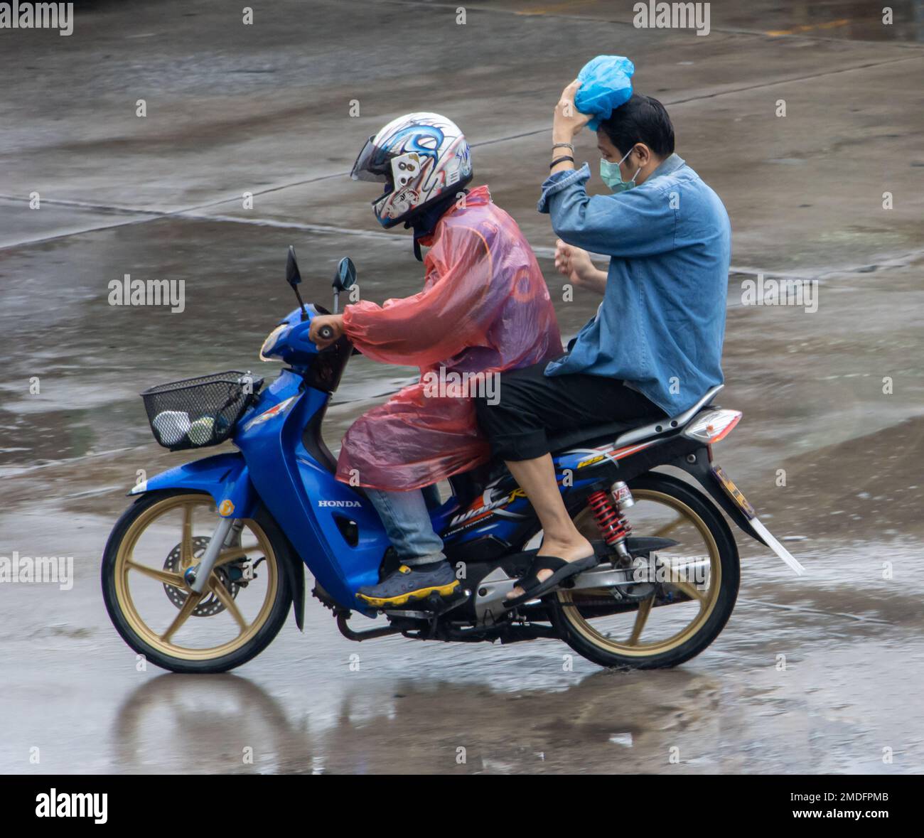 SAMUT PRAKAN, THAILANDIA, 29 2022 SETTEMBRE, moto taxi con un passeggero sotto la pioggia Foto Stock