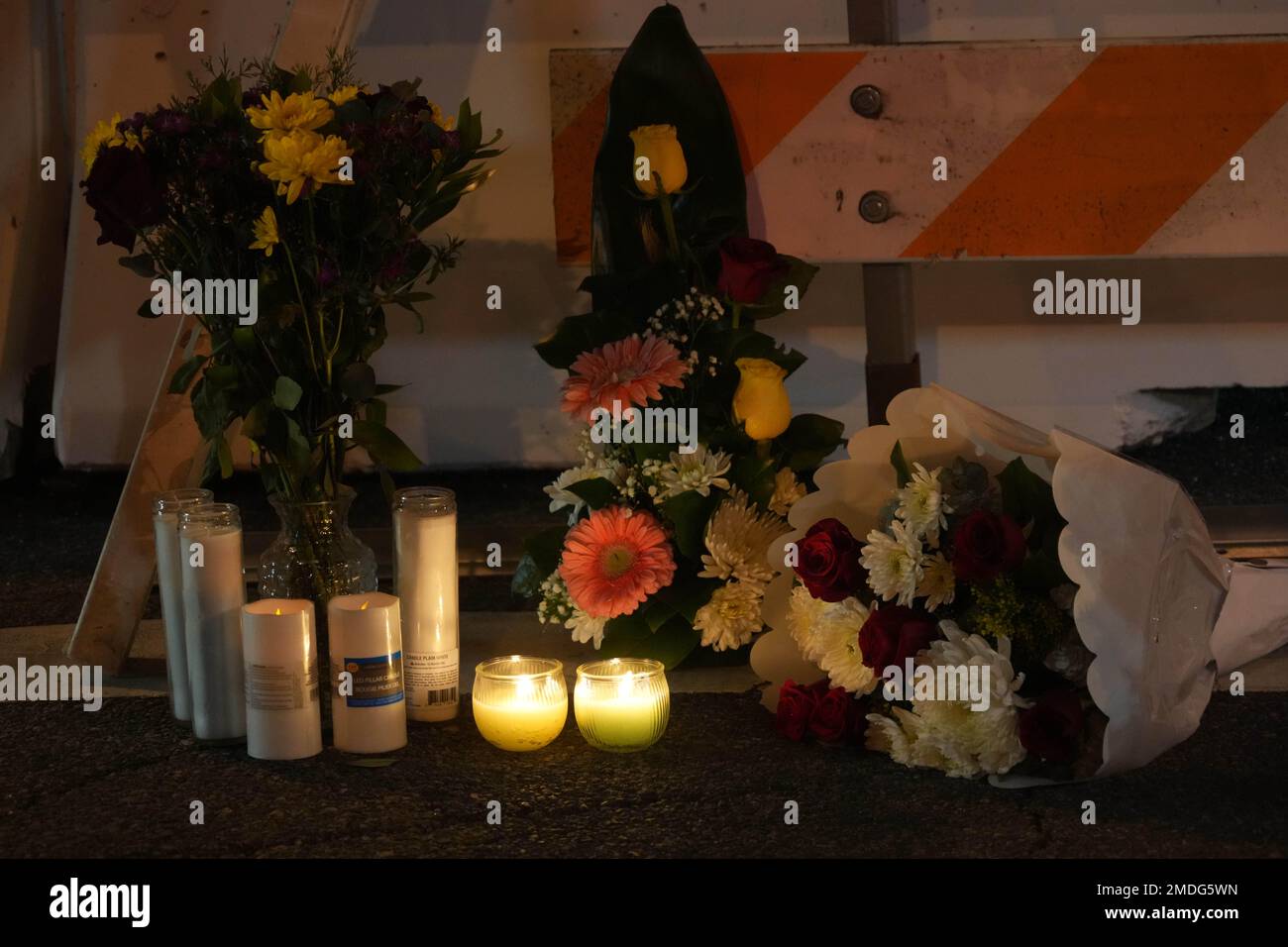 Fiori e candele in un memoriale per le vittime sparate vicino a una scena del crimine allo Star Ballroom Dance Studio di Monterey Park, California, domenica 22 gennaio 2023, una sparatoria di massa ha avuto luogo in un club di danza dopo una celebrazione del capodanno lunare, scatenando una caccia all'uomo per il sospetto. Foto Stock