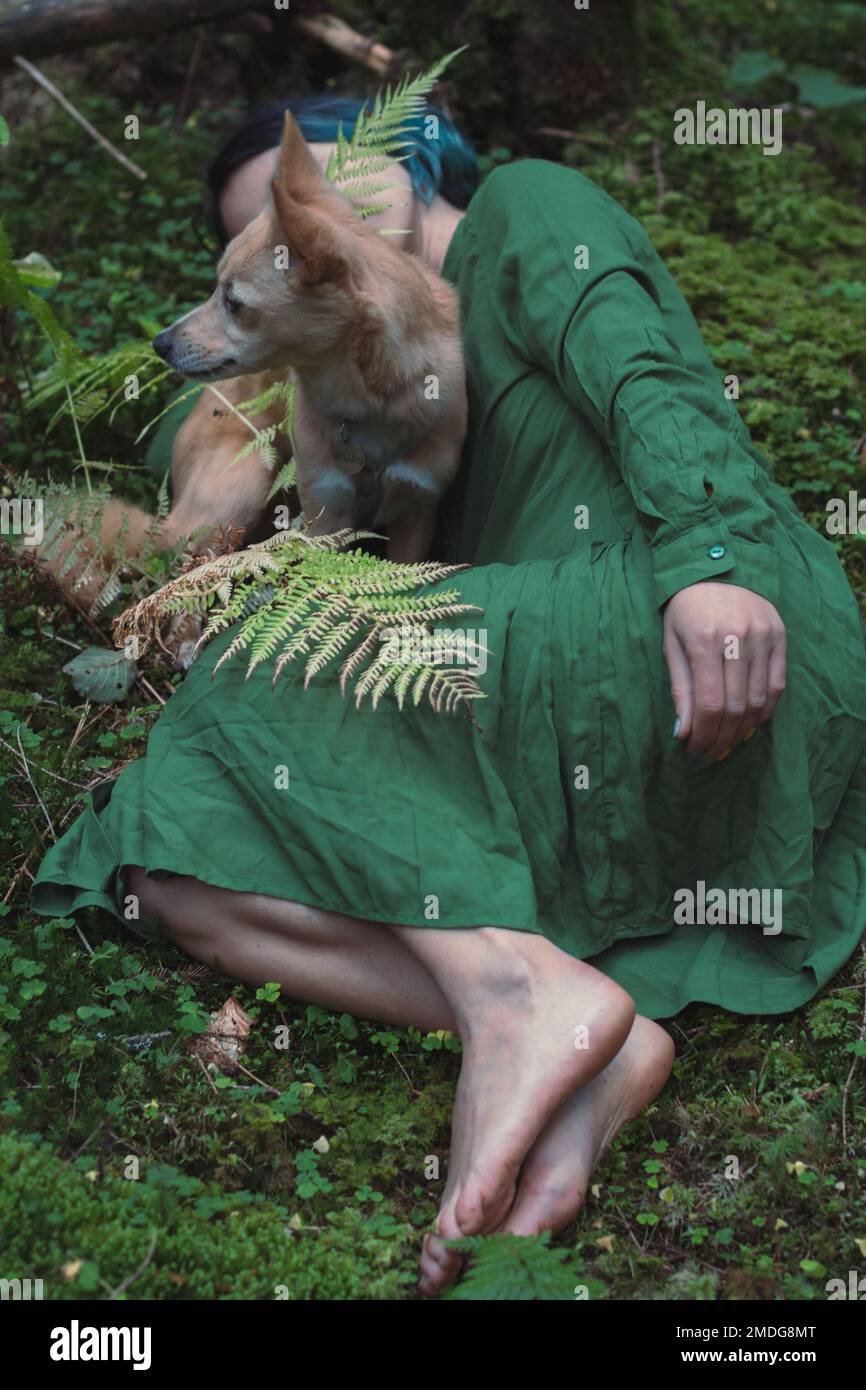 Primo piano donna con cane sdraiato sul muschio verde nella foto di concetto di foresta Foto Stock