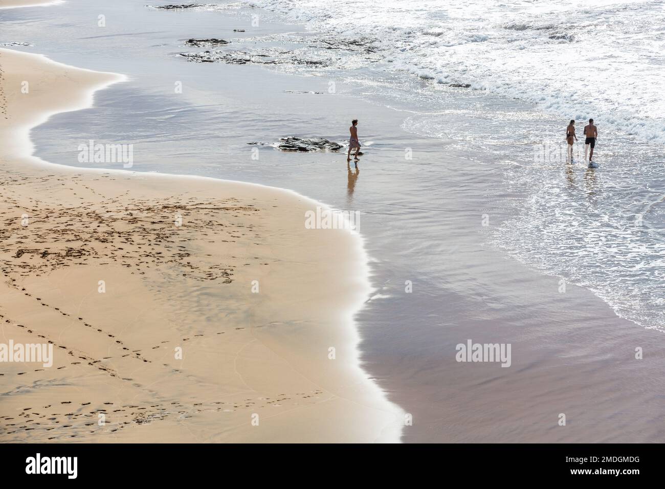 Tre persone con i piedi in acqua. Vista ad alto angolo della spiaggia di Cotillo, Fuerteventura, Isole Canarie Foto Stock