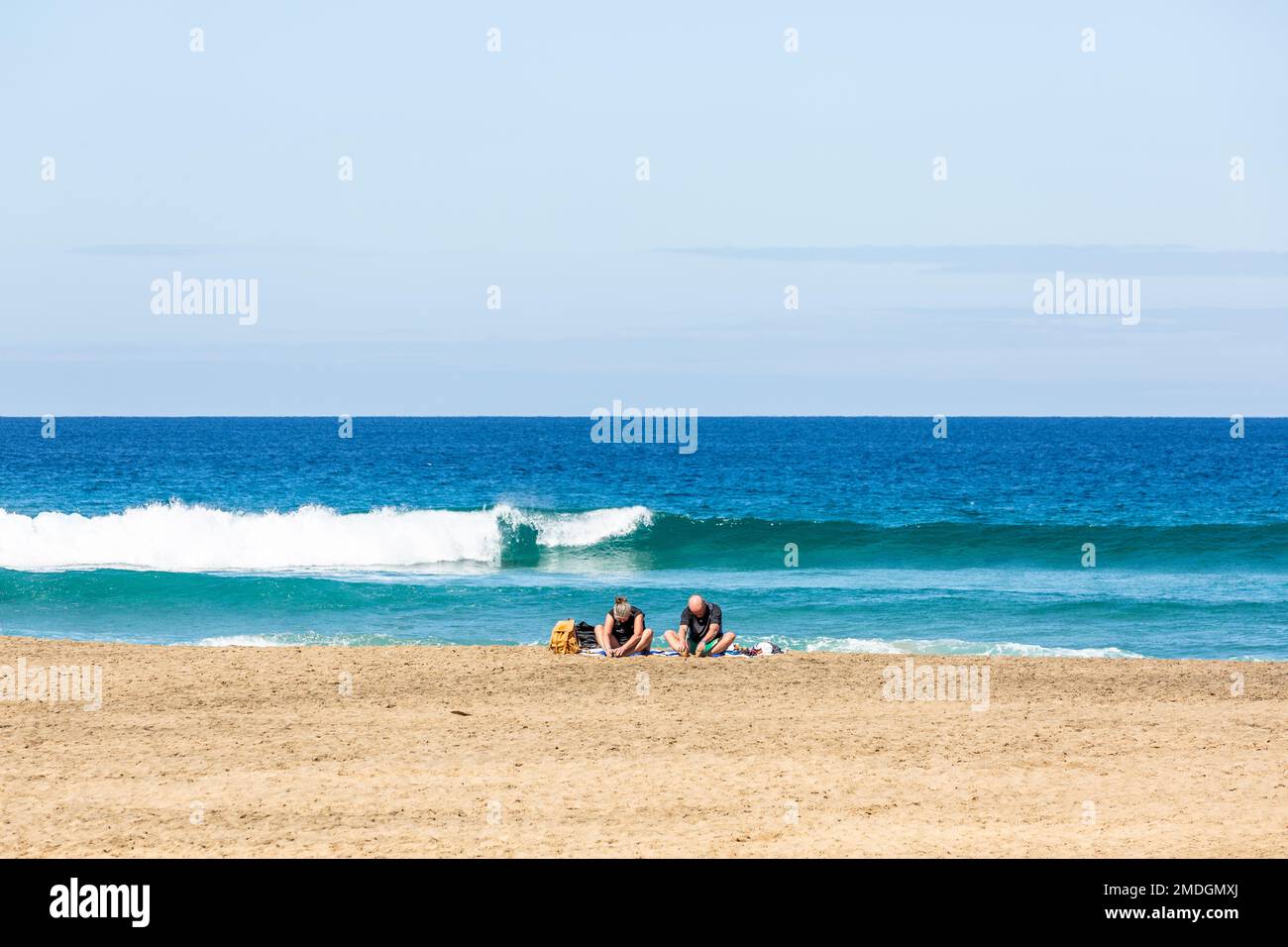 Coppia meditando sulla spiaggia di Cofete con le spalle al mare. Fuerteventura, Isole Canarie Foto Stock