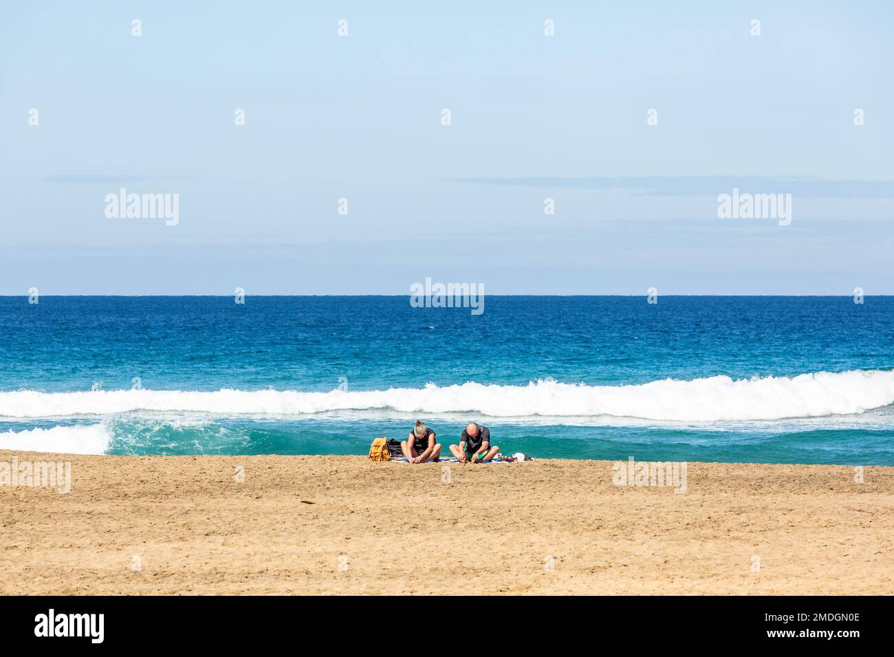 Coppia meditando sulla spiaggia di Cofete con le spalle al mare. Fuerteventura, Isole Canarie Foto Stock