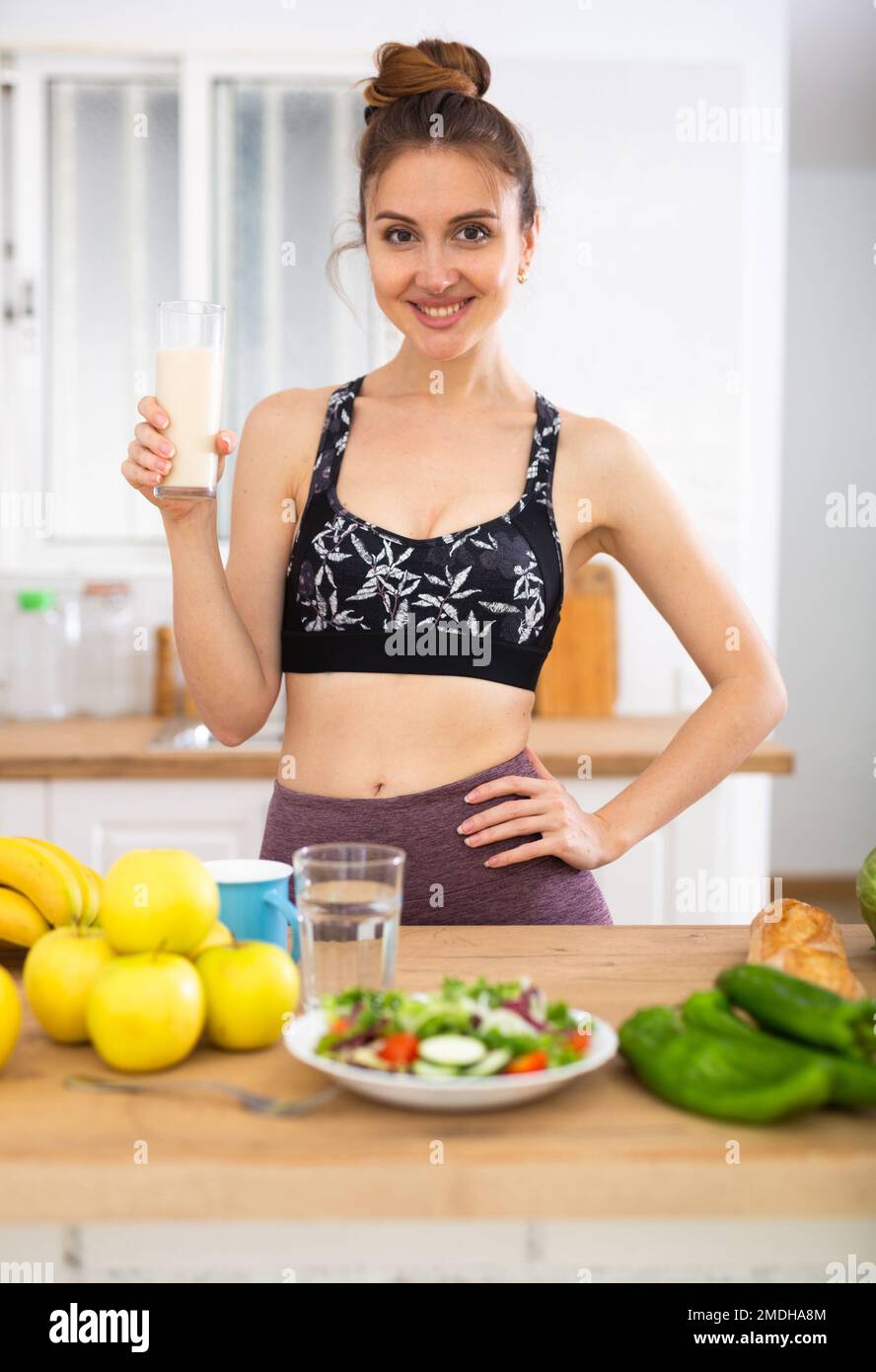 Ragazza sottile bere proteine scuotere per la perdita di peso in cucina Foto Stock