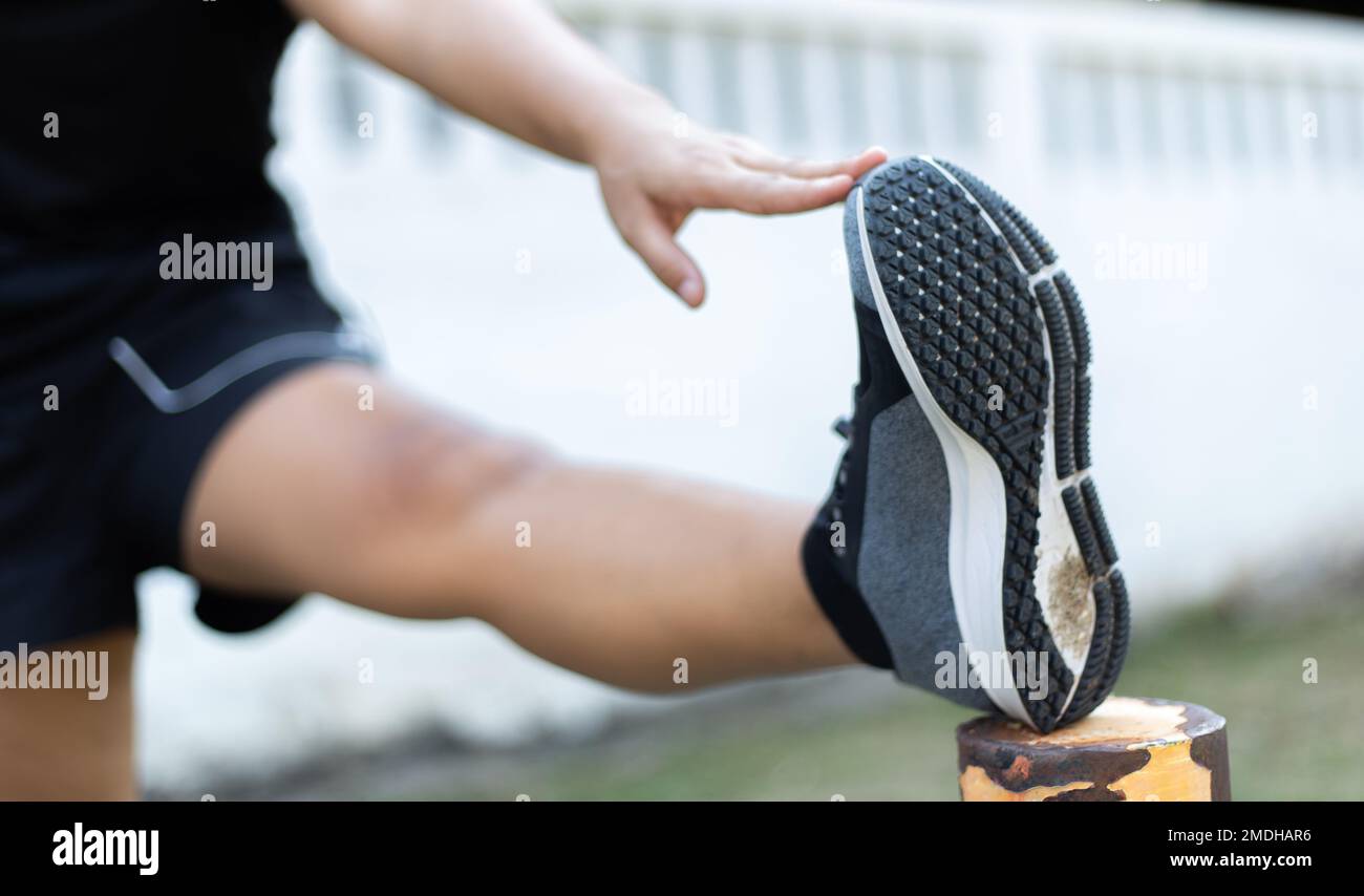 Gli atleti stanno allungando i loro muscoli per riscaldarsi o per esercitarsi nel parco al mattino, l'esercitazione per il concetto sano di lifestyle. Foto Stock