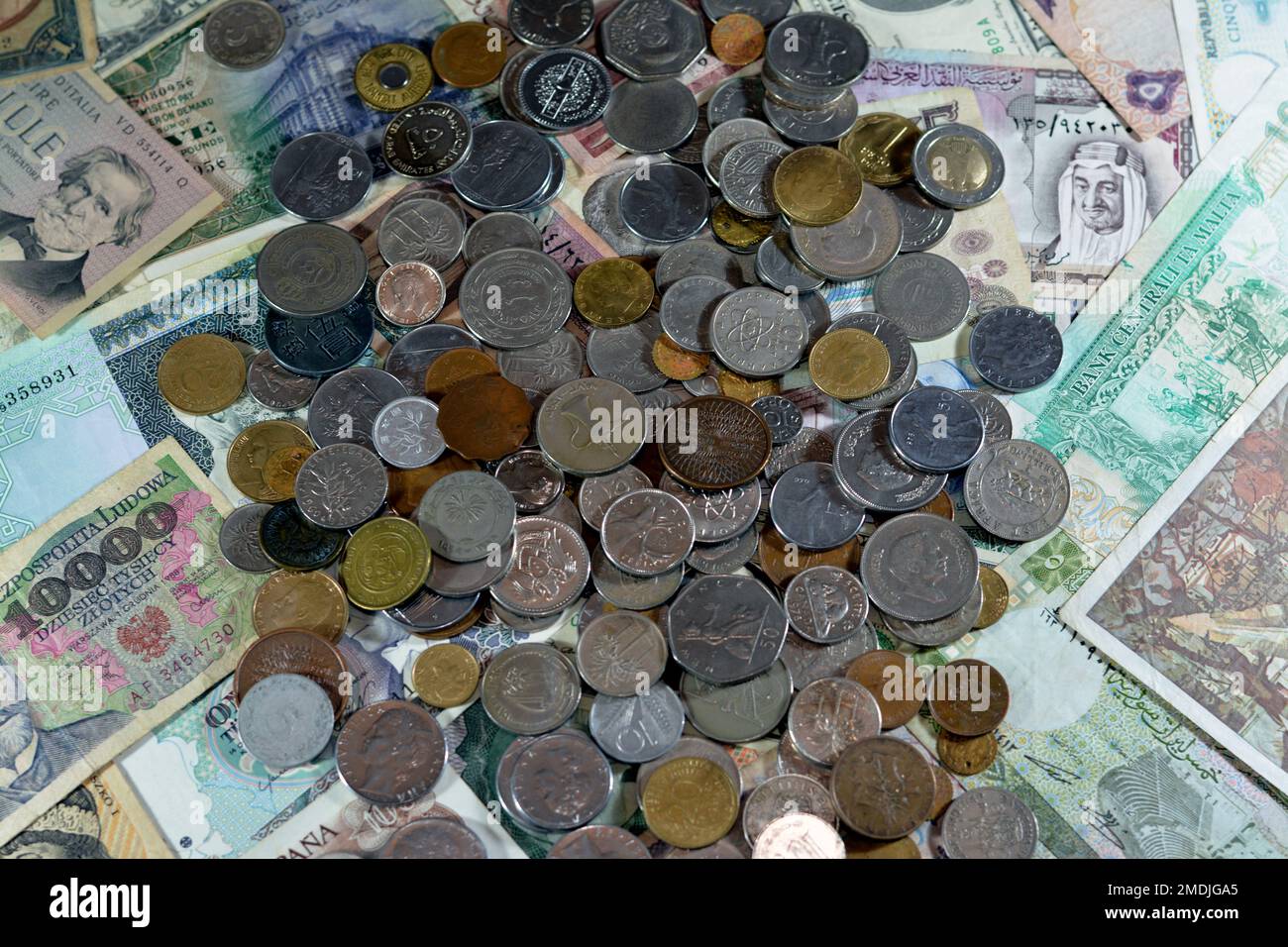 Vecchie monete su varie vecchie banconote in denaro da diversi paesi del mondo, pila di monete multiple, pila di carte di credito vintage retrò Foto Stock