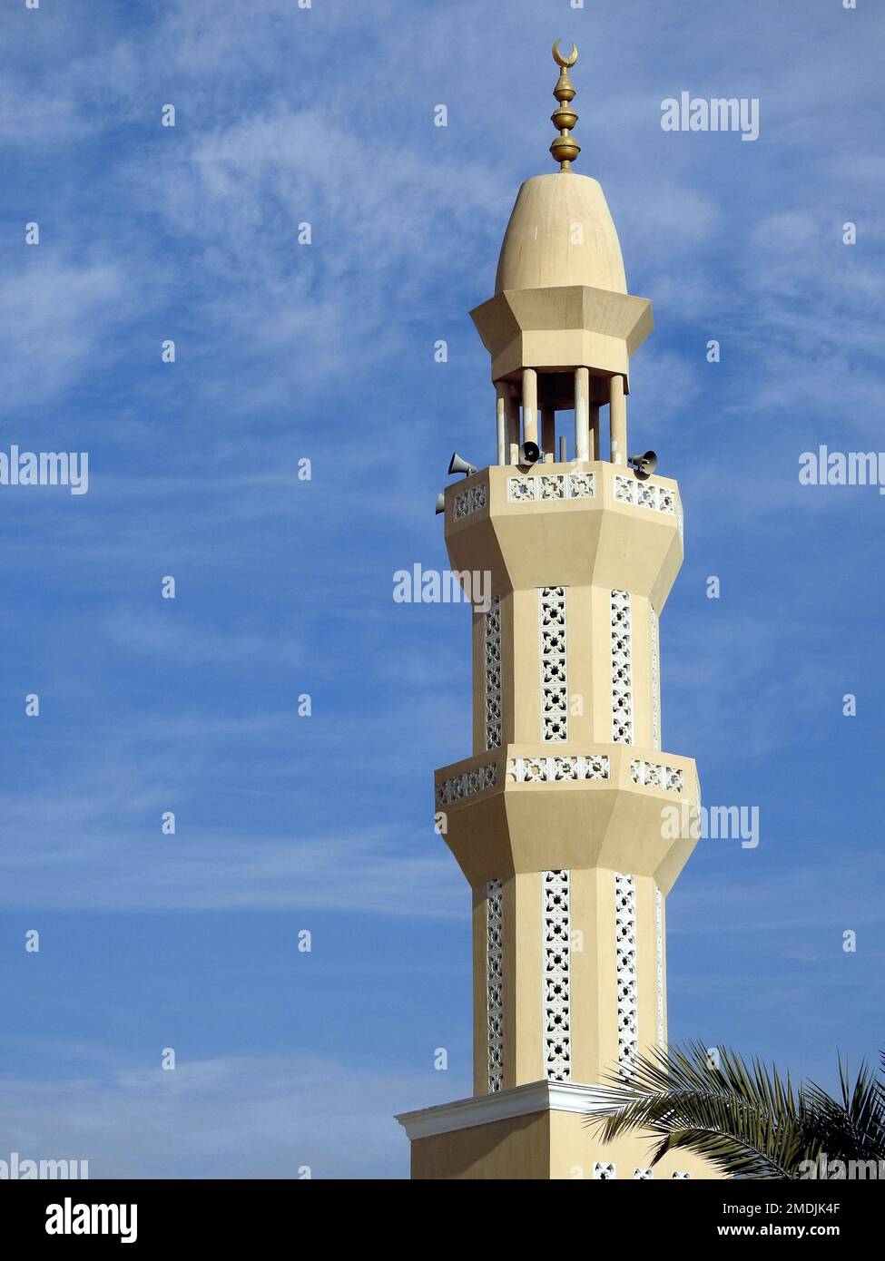 Un alto minareto di una moschea contro un bel cielo blu con nuvole alla luce del giorno, le Moschee sono il luogo di culto e di preghiere per i musulmani dove loro Foto Stock