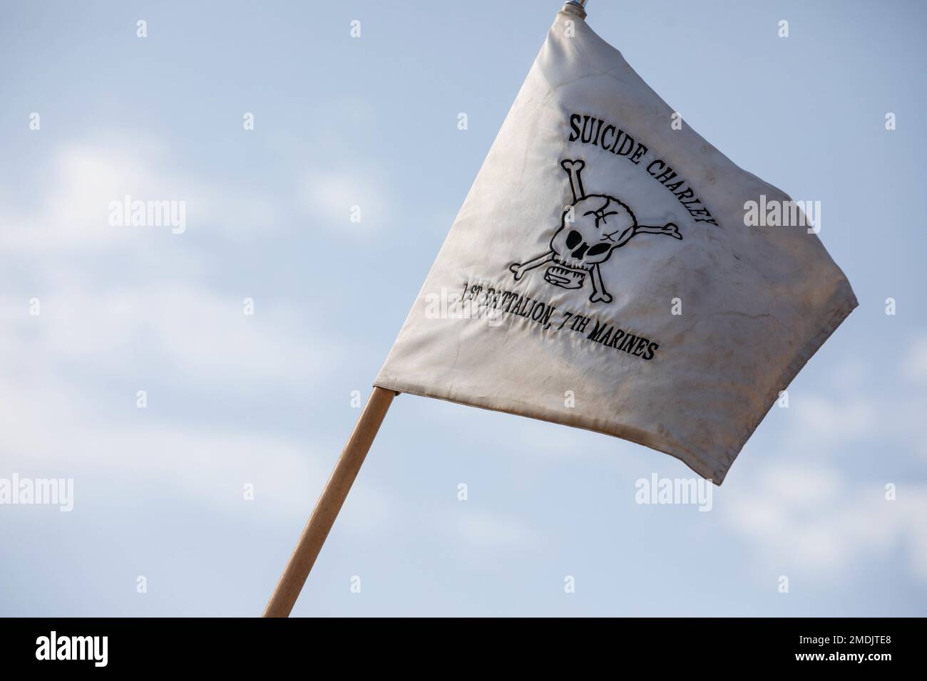 La bandiera della compagnia Suicide Charley vola a Range 400 durante l'esercizio di addestramento integrato 4-22 al Marine Corps Air Ground Combat Center, Twentynine Palms, California, 25 luglio 2022. La bandiera suicida di Charley ebbe origine durante la battaglia di Guadalcanal quando 1st battaglione, 7th reggimento marino, comandato dal Lt. Col. Chesty Puller, respinse un incessante assalto giapponese nella notte del 24 ottobre 1942. 'C' Company ha preso il peso dell'assalto e ha tenuto la linea nonostante la sofferenza molte vittime. La mattina seguente, una bandiera fatta di un paracadute di seta bianca volò sopra l'area di Charley Company portando uno skul Foto Stock