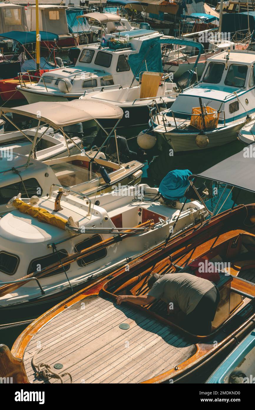 Barche da pesca ormeggiate nel piccolo porto turistico nella città di Lovran, Croazia. Messa a fuoco selettiva. Foto Stock