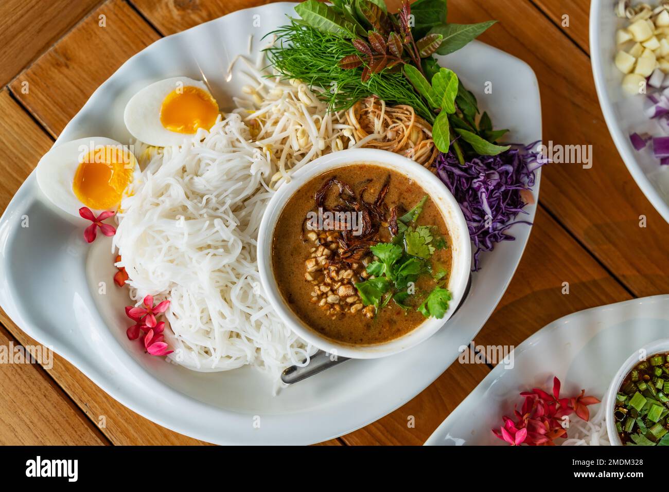 Vista dall'alto cibi thailandesi sani, vermicelli thailandesi o tagliatelle di riso con salsa di arachidi al curry, contorno con verdure biologiche e uova bollite. Foto Stock