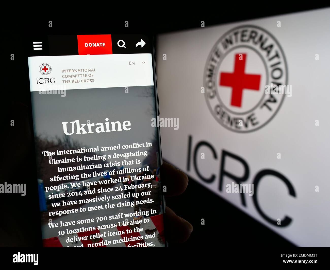 Persona che tiene uno smartphone con il sito Web del Comitato Internazionale della Croce Rossa (CICR) sullo schermo con il logo. Messa a fuoco al centro del display del telefono. Foto Stock