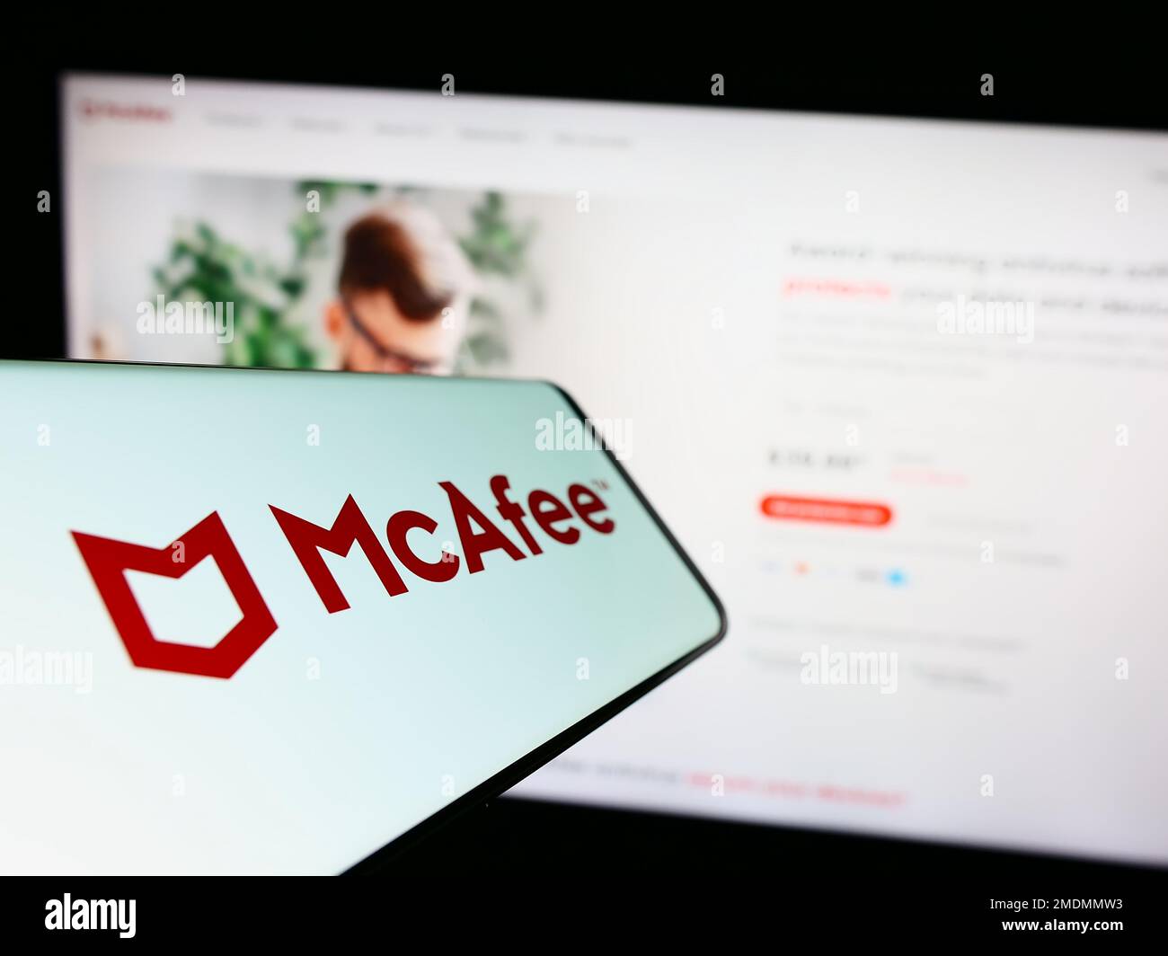 Smartphone con logo della società di software di sicurezza McAfee Corp. Sullo schermo davanti al sito Web aziendale. Messa a fuoco al centro a sinistra del display del telefono. Foto Stock