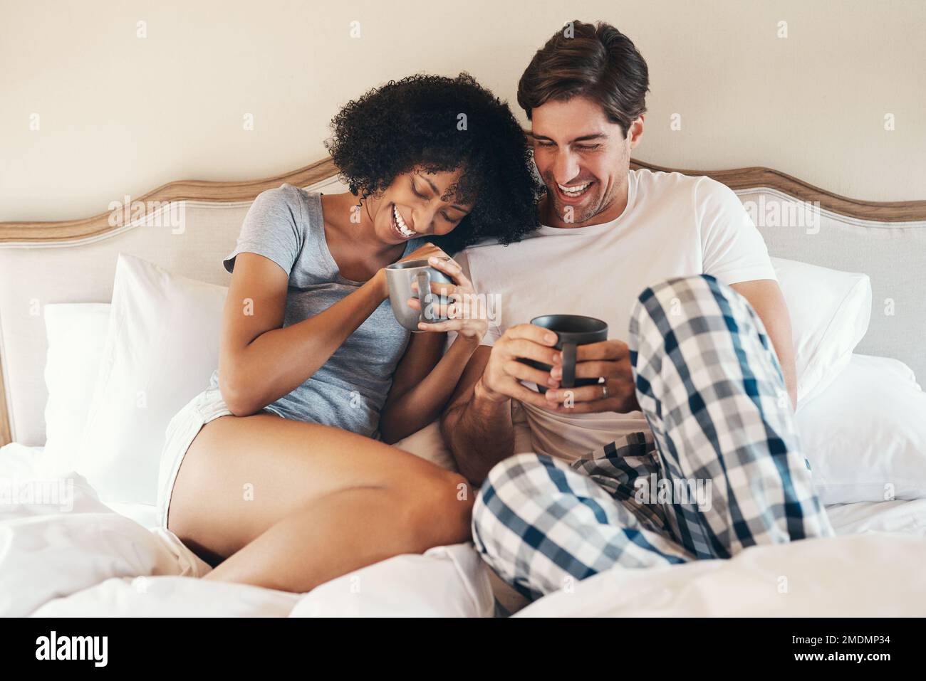 Iniziare la giornata con un caldo appunto. una giovane coppia affettuosa che beve caffè e che trascorre il tempo insieme a letto a casa. Foto Stock